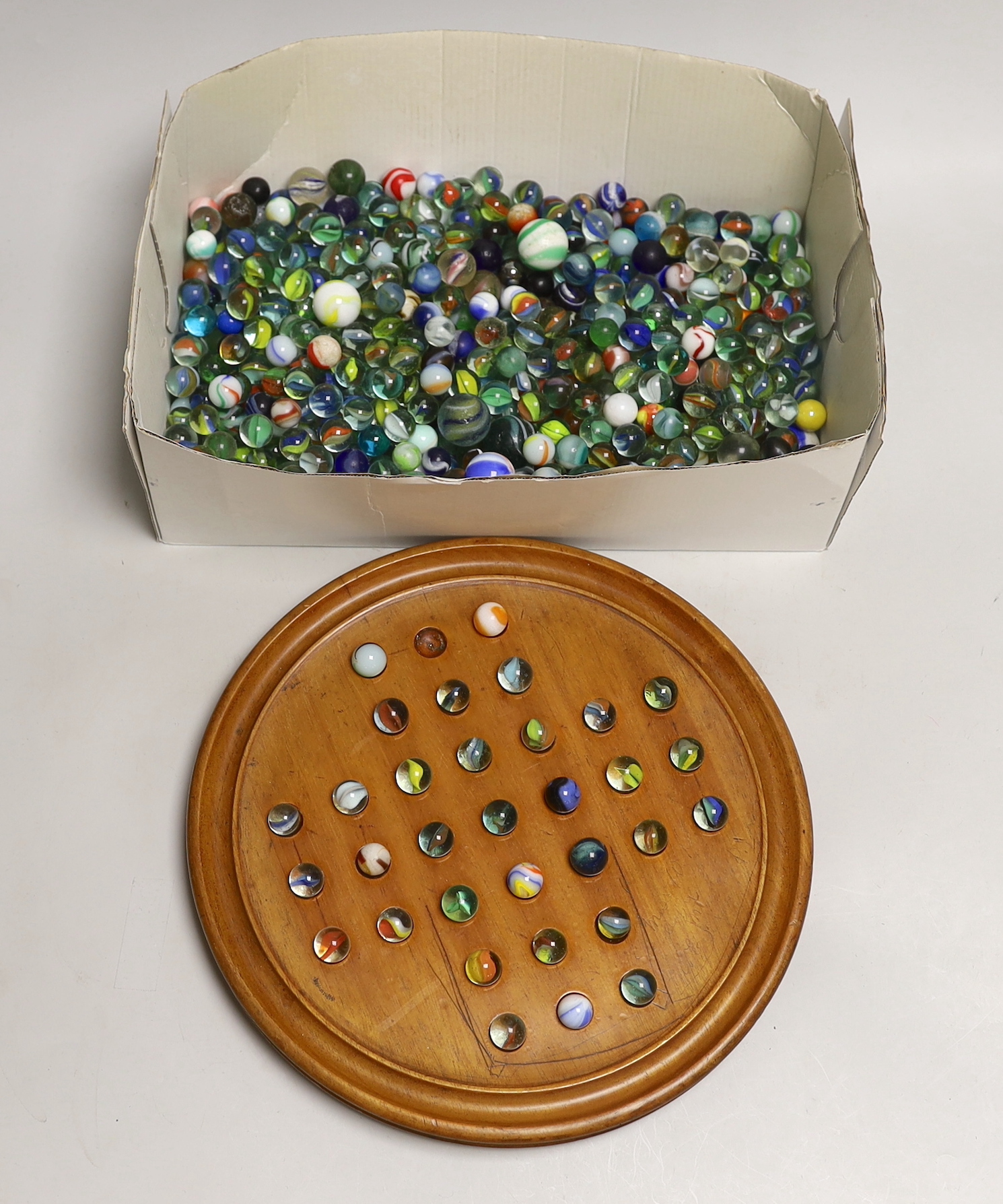 A solitaire board and a large collection marbles